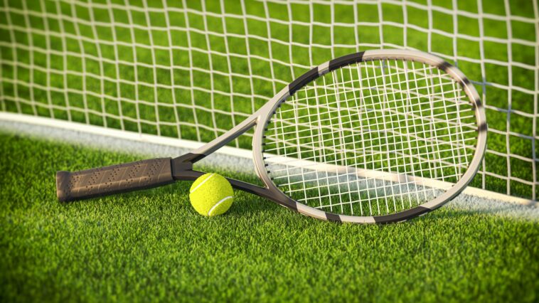 Tennis racket and tennis ball on a grass of tennis court.